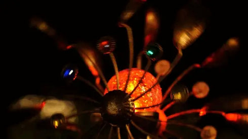 Dekorative Windmühle für Garten mit bronzefarbenen Flügeln und farbwechselnder Solarbeleuchtung bei Nacht